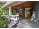 Inviting front porch with a pastel pink door, ceiling fans, and cozy seating area at 5114 N Branch Ave, Tampa, FL 33603
