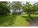 Well-manicured front yard with mature trees and landscaping surrounding a charming home with a welcoming front porch at 5114 N Branch Ave, Tampa, FL 33603