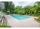 A large rectangle pool is surrounded by brick pavers and lush vegetation at 5114 N Branch Ave, Tampa, FL 33603