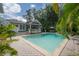 Tranquil pool area surrounded by lush palms and mature trees, offering ultimate privacy at 5114 N Branch Ave, Tampa, FL 33603