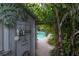 Outdoor shower with a metal privacy wall and tropical garden views by the pool at 5114 N Branch Ave, Tampa, FL 33603