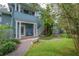 Picturesque side yard with a stone bench, lush greenery, and a charming white gate at 5114 N Branch Ave, Tampa, FL 33603