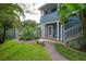 Idyllic side yard featuring a stone bench, lush grass, and a quaint white gate at 5114 N Branch Ave, Tampa, FL 33603