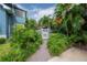 Charming pathway leading to a white picket fence, surrounded by lush landscaping and greenery at 5114 N Branch Ave, Tampa, FL 33603