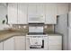 Galley kitchen features a white range, microwave, and stone-look backsplash at 5238 Vera St, Zephyrhills, FL 33542