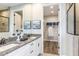 Elegant bathroom featuring double vanity with granite countertops and a glimpse into the walk-in closet at 6206 Timberdale Ave, Wesley Chapel, FL 33545