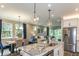Open-concept kitchen and dining area with stainless steel appliances and granite countertop island at 6206 Timberdale Ave, Wesley Chapel, FL 33545