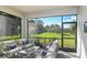 Screened lanai with outdoor furniture overlooking a lush backyard and a sunny sky at 6206 Timberdale Ave, Wesley Chapel, FL 33545