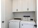 Convenient laundry room with modern washer and dryer units, ample cabinet space at 6206 Timberdale Ave, Wesley Chapel, FL 33545