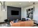 Contemporary living room featuring leather sofa, tile accent wall, and modern decor at 6206 Timberdale Ave, Wesley Chapel, FL 33545