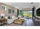 Cozy living room with a white sofa, wood coffee table, and sliding glass doors at 6206 Timberdale Ave, Wesley Chapel, FL 33545