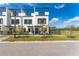 Charming townhome featuring a modern exterior with a black fence, a manicured lawn, and a rooftop deck at 6207 64Th N Way, Pinellas Park, FL 33781