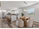 Well-lit kitchen featuring an island with seating, white cabinets, stainless steel appliances, and an adjacent dining area at 6207 64Th N Way, Pinellas Park, FL 33781