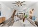 Spacious open-plan living area flows into the kitchen with hardwood flooring and a modern staircase at 6207 64Th N Way, Pinellas Park, FL 33781