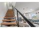 Modern staircase with wooden steps and metal railings leading to a kitchen with island seating at 6207 64Th N Way, Pinellas Park, FL 33781