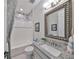 Well-lit bathroom with a granite countertop, decorative mirror, and tiled shower-tub combo at 7328 Paradiso Dr, Apollo Beach, FL 33572