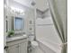 Bathroom featuring a granite countertop, decorative mirror, and tiled shower-tub combo at 7328 Paradiso Dr, Apollo Beach, FL 33572