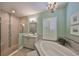 Bright bathroom featuring a shower and soaking tub, complemented by white shutters for natural light at 7328 Paradiso Dr, Apollo Beach, FL 33572