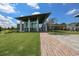 Modern community clubhouse featuring a welcoming entrance, well-manicured lawn, and a brick pathway at 7328 Paradiso Dr, Apollo Beach, FL 33572