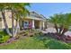 Charming home with well-manicured lawn and lush landscaping, featuring mature palm trees at 7328 Paradiso Dr, Apollo Beach, FL 33572