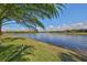 A serene lake view from the property with manicured lawn and clear blue skies at 7328 Paradiso Dr, Apollo Beach, FL 33572