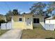 Charming single-story home with a well-manicured lawn, gated walkway, and freshly painted exterior at 7411 S Elliott St, Tampa, FL 33616