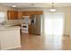 Well-lit kitchen with a stainless steel refrigerator, breakfast bar, and access to the dining area at 7411 S Elliott St, Tampa, FL 33616