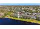 Extensive aerial view of neighborhood homes near a lake with red marker, surrounded by greenery and mature trees at 7425 Terrace River Dr, Temple Terrace, FL 33637