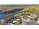 Wide aerial view of homes near a lake, showing lush greenery, a pool, and a rooftop terrace at 7425 Terrace River Dr, Temple Terrace, FL 33637