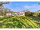 Expansive backyard featuring lush green grass and a white fenced-in patio with seating and an umbrella at 7425 Terrace River Dr, Temple Terrace, FL 33637