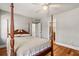 Bedroom showcasing a wooden four-poster bed with doorway to a bathroom at 7425 Terrace River Dr, Temple Terrace, FL 33637