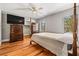 Bedroom featuring hardwood floors, ceiling fan, and large dresser with TV at 7425 Terrace River Dr, Temple Terrace, FL 33637
