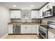 Well-lit kitchen with stainless steel appliances, granite counters, and sleek white cabinetry at 7425 Terrace River Dr, Temple Terrace, FL 33637