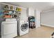 Functional laundry area with washer, dryer, storage shelves, and white cabinets at 7425 Terrace River Dr, Temple Terrace, FL 33637