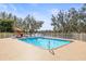 Sparkling in-ground pool surrounded by a white fence and lounge chairs, perfect for relaxation at 7425 Terrace River Dr, Temple Terrace, FL 33637