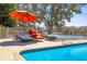Relaxing poolside view with lounge chairs and umbrella overlooking the lake at 7425 Terrace River Dr, Temple Terrace, FL 33637