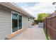 Paver patio and gray house featuring a sliding glass door, a privacy fence, and landscaping at 800 51St S St, Gulfport, FL 33707