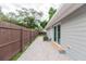 Gray house and paver patio featuring a sliding glass door, a privacy fence, and landscaping at 800 51St S St, Gulfport, FL 33707