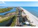 An aerial view showcases beachfront homes and condos along a pristine sandy beach overlooking the ocean and intercoastal waterway at 8083 Bayhaven Dr, Seminole, FL 33776