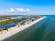 Expansive aerial perspective of coastal real estate, showcasing the beach and ocean at 8083 Bayhaven Dr, Seminole, FL 33776