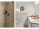 Neutral bathroom featuring a tiled walk-in shower, toilet, vanity with sink and decorative mirror at 8083 Bayhaven Dr, Seminole, FL 33776