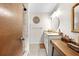 Bathroom featuring a neutral vanity with a sink, wall mirror, tiled floors, and a walk-in shower at 8083 Bayhaven Dr, Seminole, FL 33776