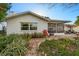 Back exterior view of the house with a screened lanai, patio, and lush landscaping at 8083 Bayhaven Dr, Seminole, FL 33776