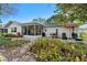 Exterior view of the home showcasing the backyard, patio, and lush garden landscape at 8083 Bayhaven Dr, Seminole, FL 33776