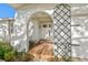 Close up exterior view of the front door with an archway and decorative security gate leading to the garage at 8083 Bayhaven Dr, Seminole, FL 33776