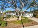 Charming home featuring a well-manicured lawn, mature shade tree, neutral color palette, and an attached two-car garage at 8083 Bayhaven Dr, Seminole, FL 33776