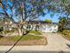 Charming home featuring a well-manicured lawn, mature shade tree, neutral color palette, and an attached two-car garage at 8083 Bayhaven Dr, Seminole, FL 33776