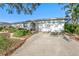 Inviting home exterior with a white facade, well-kept yard, and an attached two-car garage with mature trees at 8083 Bayhaven Dr, Seminole, FL 33776
