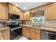 Kitchen features stainless steel appliances, wooden cabinetry, granite countertops, and tiled floors at 8083 Bayhaven Dr, Seminole, FL 33776