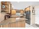 Well-lit kitchen featuring granite countertops, wooden cabinetry, stainless steel appliances, and tiled floors at 8083 Bayhaven Dr, Seminole, FL 33776